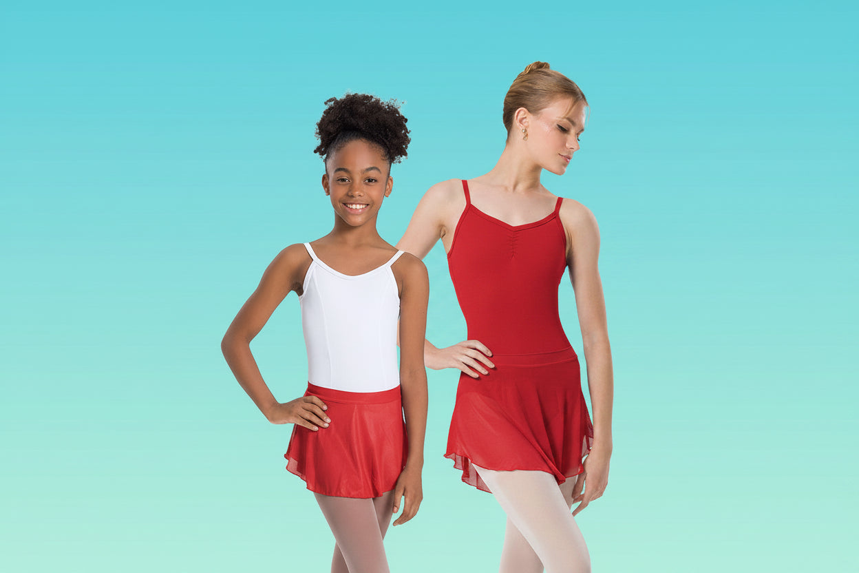 Two young dancers posing in blue and white leotards and skirts against a light blue gradient background.